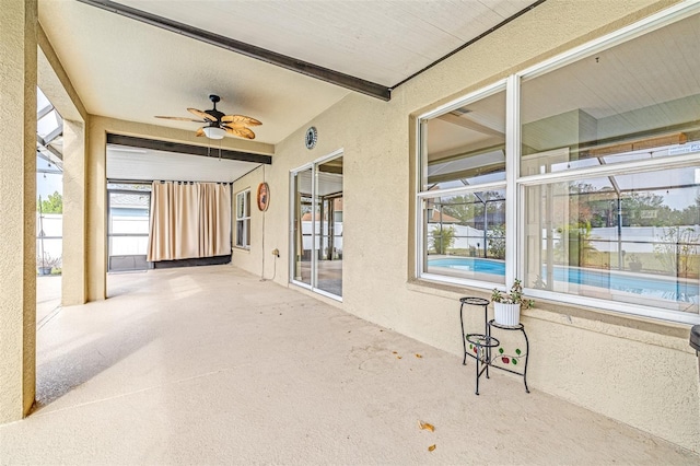 sunroom featuring ceiling fan, beam ceiling, and a healthy amount of sunlight