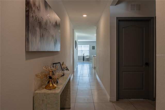 hall with light tile patterned floors