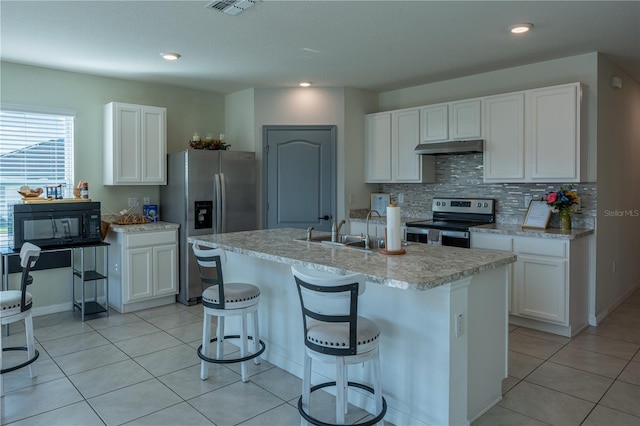 kitchen with appliances with stainless steel finishes, a kitchen island with sink, sink, and white cabinets