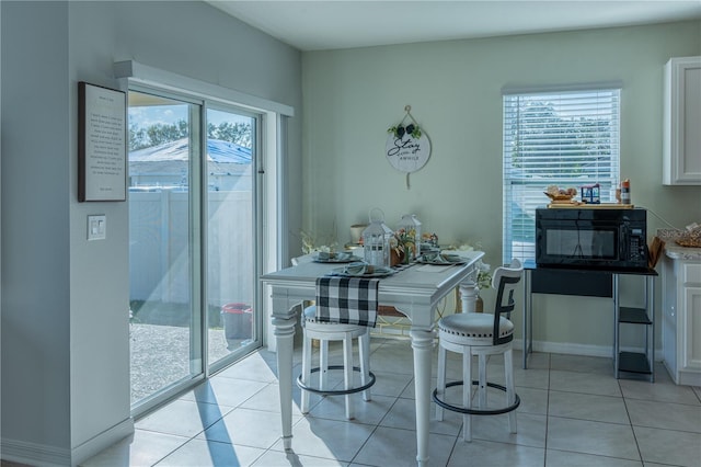 tiled dining room with a healthy amount of sunlight