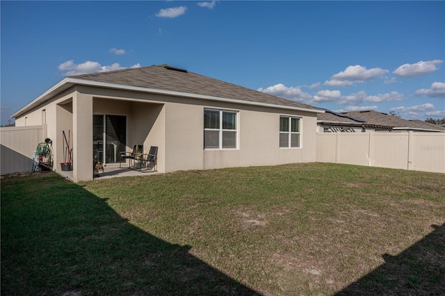 back of property featuring a yard and a patio area