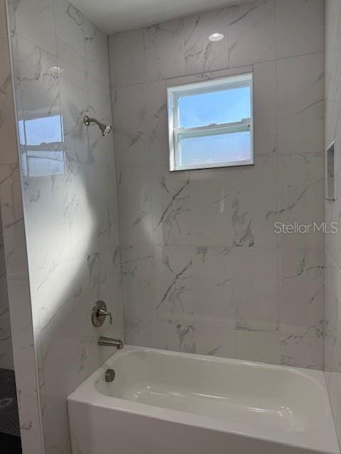 bathroom featuring tiled shower / bath