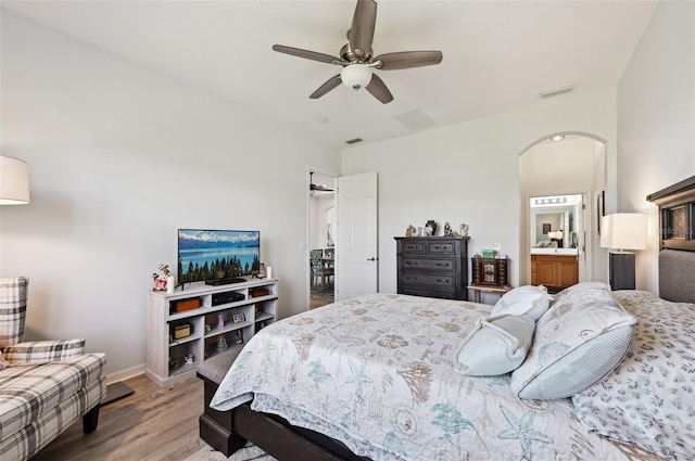 bedroom featuring ceiling fan, hardwood / wood-style floors, and ensuite bath