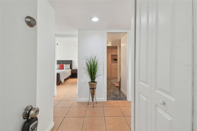 corridor featuring light tile patterned floors and baseboards