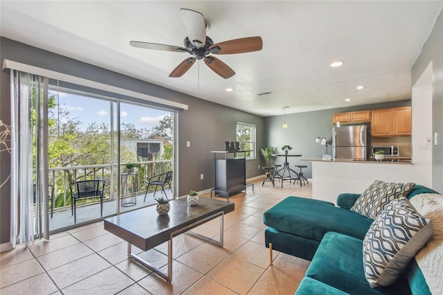 living area with light tile patterned flooring, recessed lighting, baseboards, and ceiling fan