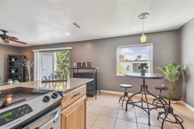 kitchen featuring stainless steel electric range oven, decorative light fixtures, light brown cabinets, light tile patterned floors, and ceiling fan