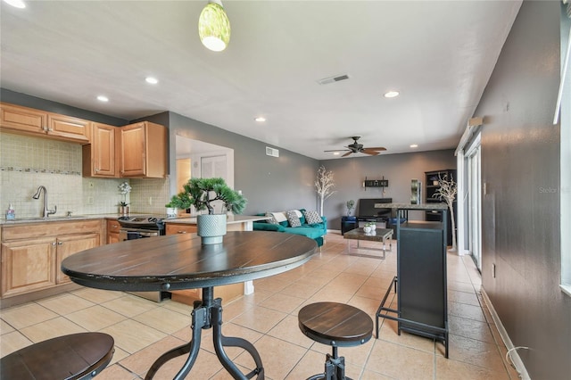 kitchen featuring visible vents, recessed lighting, ceiling fan, a sink, and backsplash