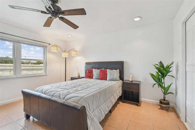 bedroom with light tile patterned floors, a ceiling fan, and baseboards