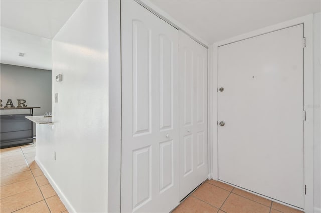 hall featuring light tile patterned flooring and visible vents