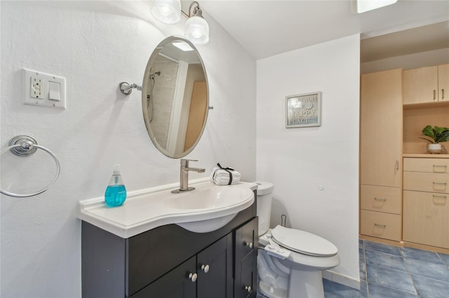 bathroom with tile patterned flooring, vanity, and toilet