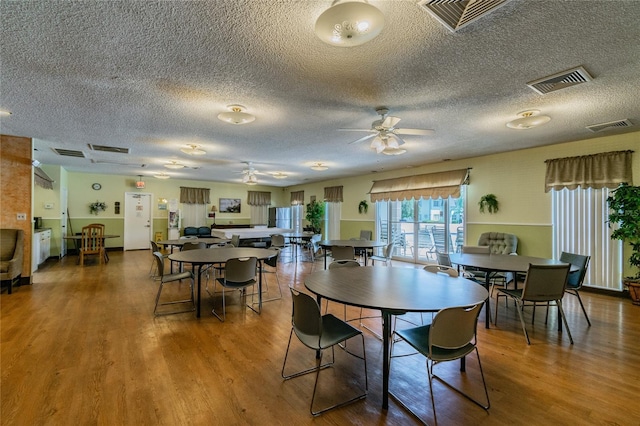 dining room with hardwood / wood-style flooring, a textured ceiling, and ceiling fan