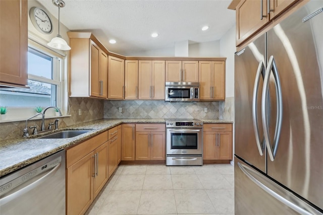 kitchen featuring pendant lighting, sink, decorative backsplash, and stainless steel appliances