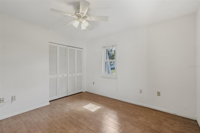 unfurnished bedroom with light hardwood / wood-style floors, a closet, and ceiling fan