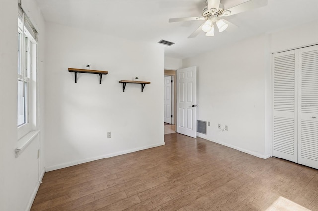 unfurnished bedroom featuring hardwood / wood-style flooring, a closet, and ceiling fan