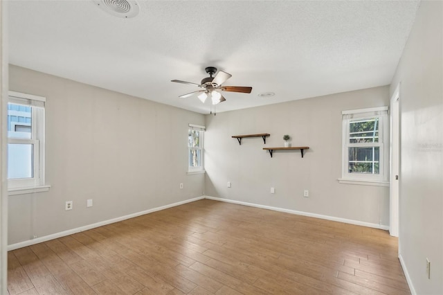 unfurnished room with ceiling fan, plenty of natural light, and light wood-type flooring