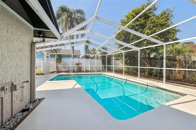 view of swimming pool featuring a patio and glass enclosure