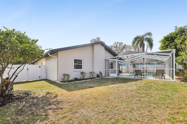 back of property with a yard, a lanai, a fenced in pool, and a patio area