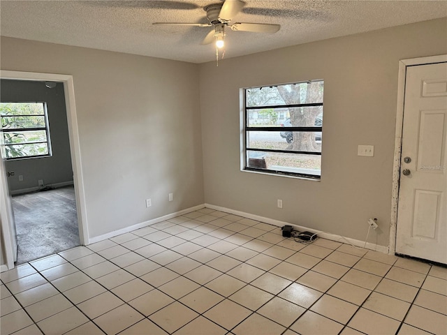 unfurnished room with light tile patterned floors, a textured ceiling, and ceiling fan