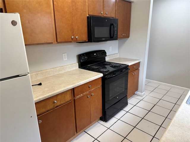 kitchen with light tile patterned flooring and black appliances