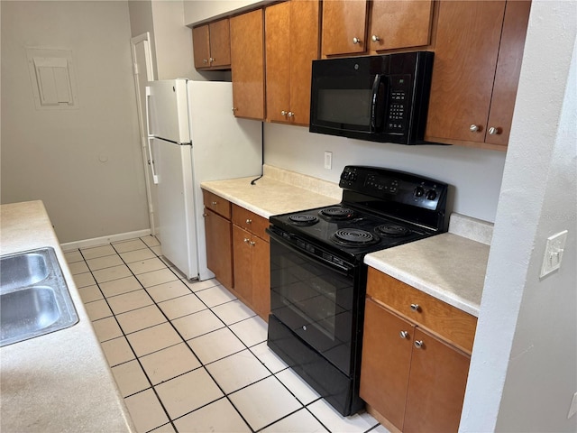 kitchen featuring sink, black appliances, and light tile patterned flooring