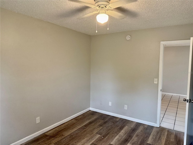 spare room featuring ceiling fan, dark hardwood / wood-style flooring, and a textured ceiling