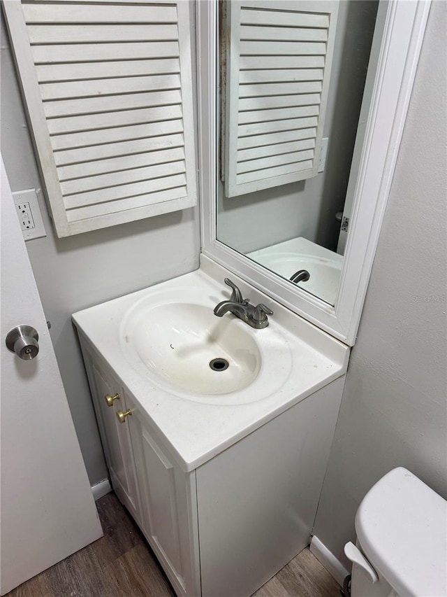 bathroom featuring vanity, hardwood / wood-style floors, and toilet