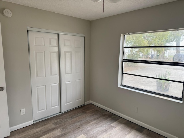 unfurnished bedroom with a closet, a textured ceiling, and light wood-type flooring