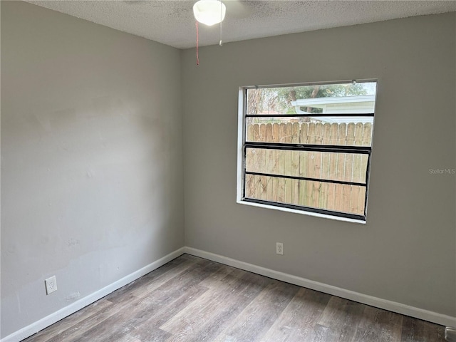 spare room featuring a textured ceiling and light wood-type flooring