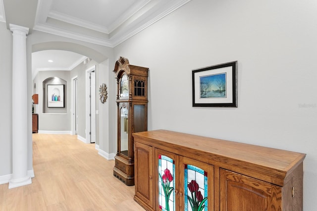 hallway featuring ornamental molding, light hardwood / wood-style floors, and decorative columns