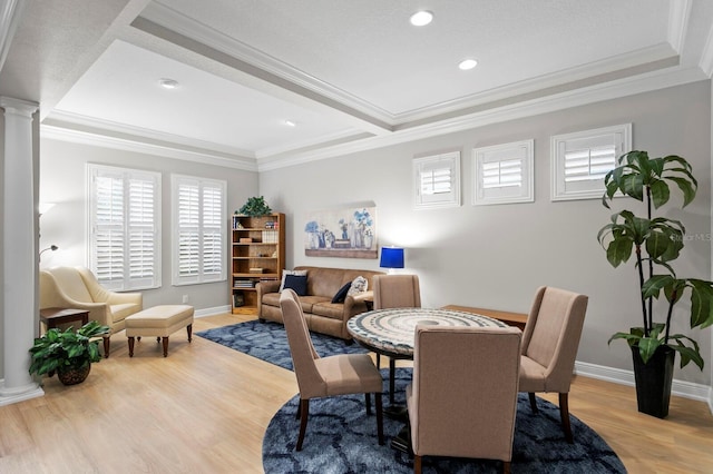 dining area with crown molding, light hardwood / wood-style floors, and ornate columns