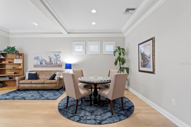 dining area with crown molding and light hardwood / wood-style floors