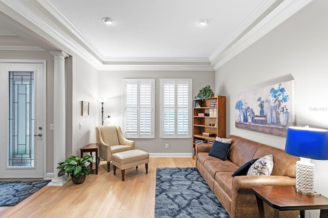 living room featuring hardwood / wood-style flooring, ornamental molding, and decorative columns