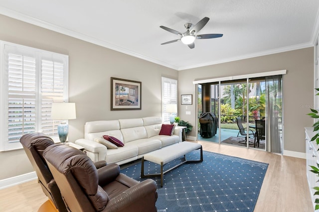 living room featuring ornamental molding, light hardwood / wood-style floors, and ceiling fan