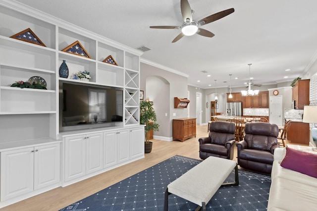 living room featuring ornamental molding, ceiling fan with notable chandelier, and light wood-type flooring