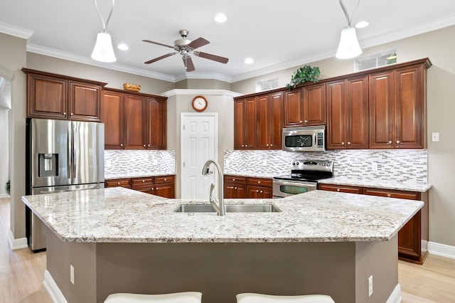 kitchen with appliances with stainless steel finishes, a large island, a breakfast bar, and sink