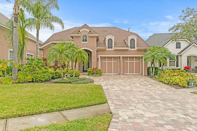 french country inspired facade with a garage and a front lawn