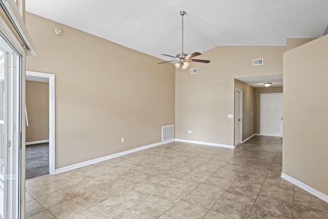 tiled spare room with ceiling fan and high vaulted ceiling