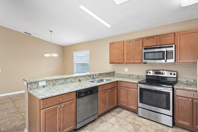 kitchen with appliances with stainless steel finishes, pendant lighting, sink, kitchen peninsula, and light stone countertops