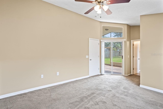 empty room with ceiling fan, a textured ceiling, and carpet flooring