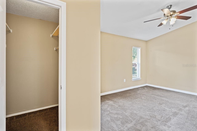 spare room with a textured ceiling, ceiling fan, and carpet flooring