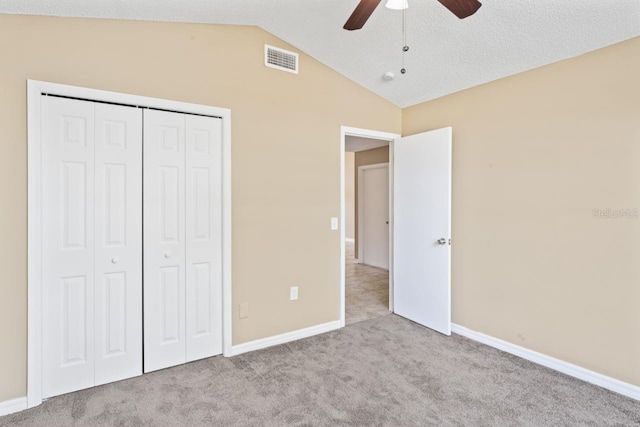 unfurnished bedroom with lofted ceiling, light colored carpet, ceiling fan, and a closet