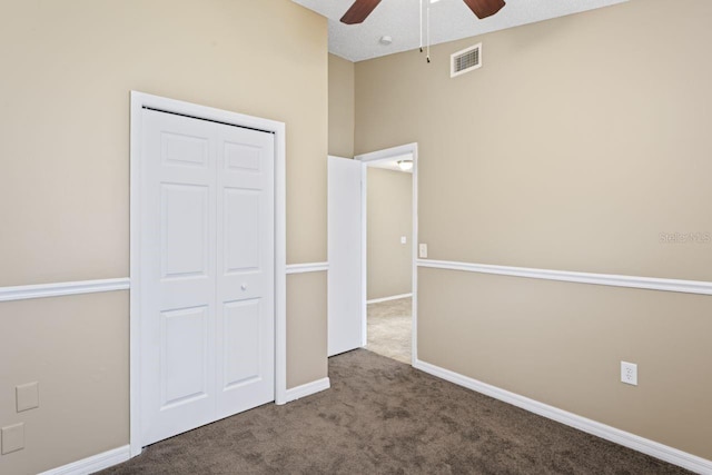 unfurnished bedroom featuring ceiling fan, lofted ceiling, carpet flooring, and a closet