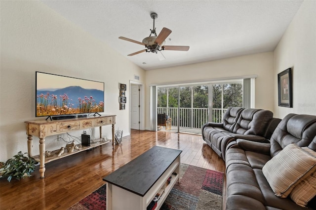 living room featuring hardwood / wood-style floors, a textured ceiling, and ceiling fan