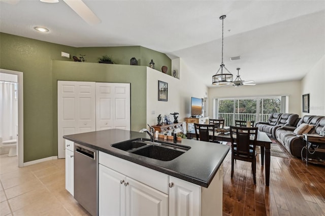 kitchen featuring pendant lighting, sink, dishwasher, an island with sink, and white cabinets