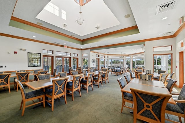 dining area with a raised ceiling, crown molding, carpet flooring, and french doors