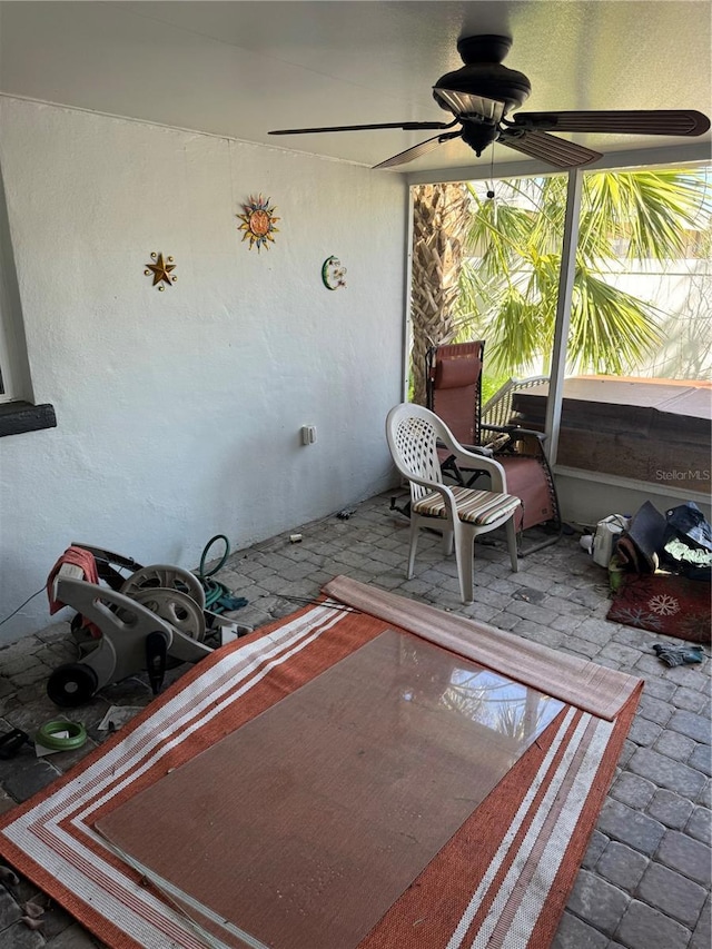 unfurnished sunroom with a ceiling fan