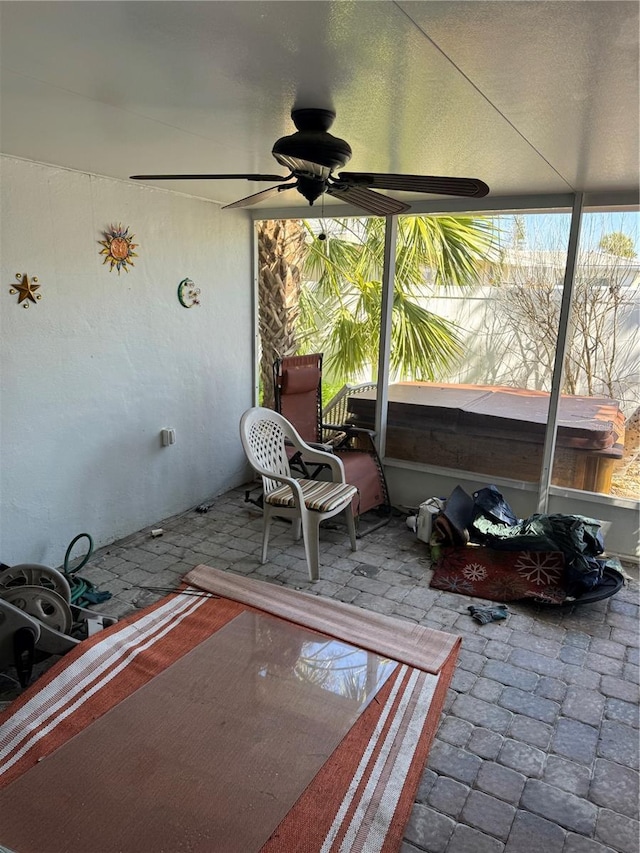 unfurnished sunroom with ceiling fan