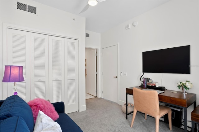 carpeted home office featuring ceiling fan