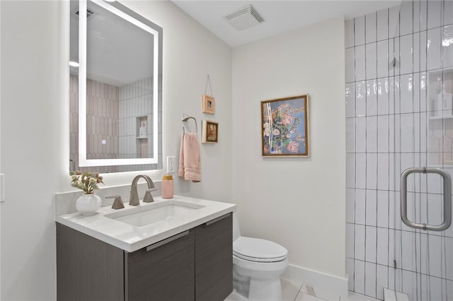 bathroom featuring vanity, a shower with shower door, and toilet