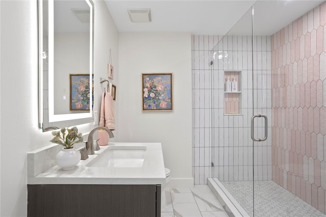 bathroom featuring vanity, toilet, and a shower with shower door